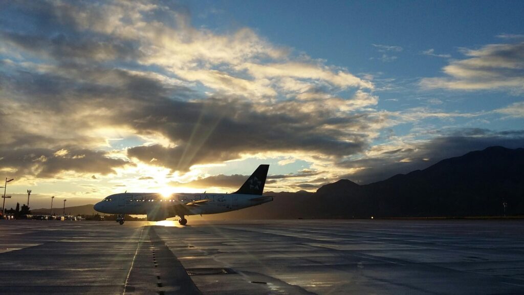 A beautiful silhouette of an airplane on a runway during a vibrant sunset at Čilipi Airport, Croatia.