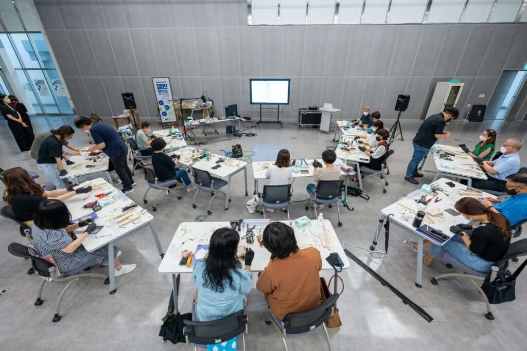 Overhead view of a hands-on classroom workshop with diverse students using hi-tech equipment.