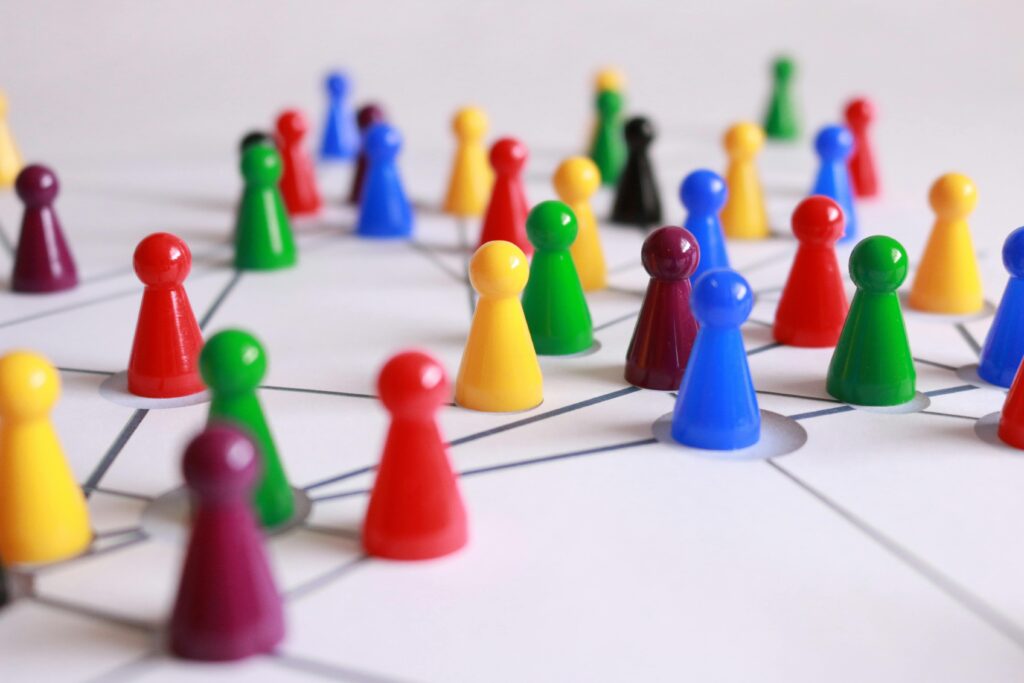 A strategic arrangement of colorful pawns connected on a game board, symbolizing networking and teamwork.