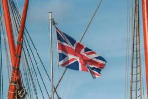 Union Jack flag waving prominently from a ship mast, capturing a sense of travel and patriotism.