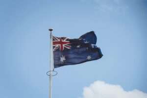 Australian national flag waving on a flagpole against a clear blue sky in Perth.